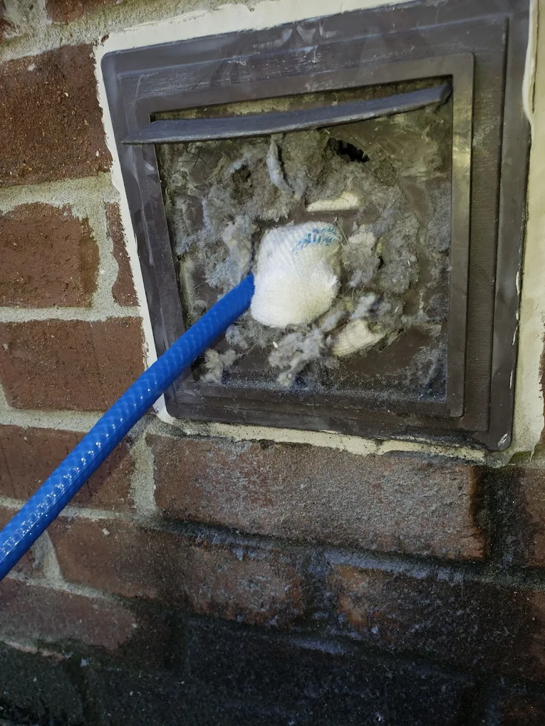 Severely clogged dryer vent with sock and lint buildup - fire hazard